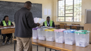 Kenyan voter holding six ballot papers inside a polling station